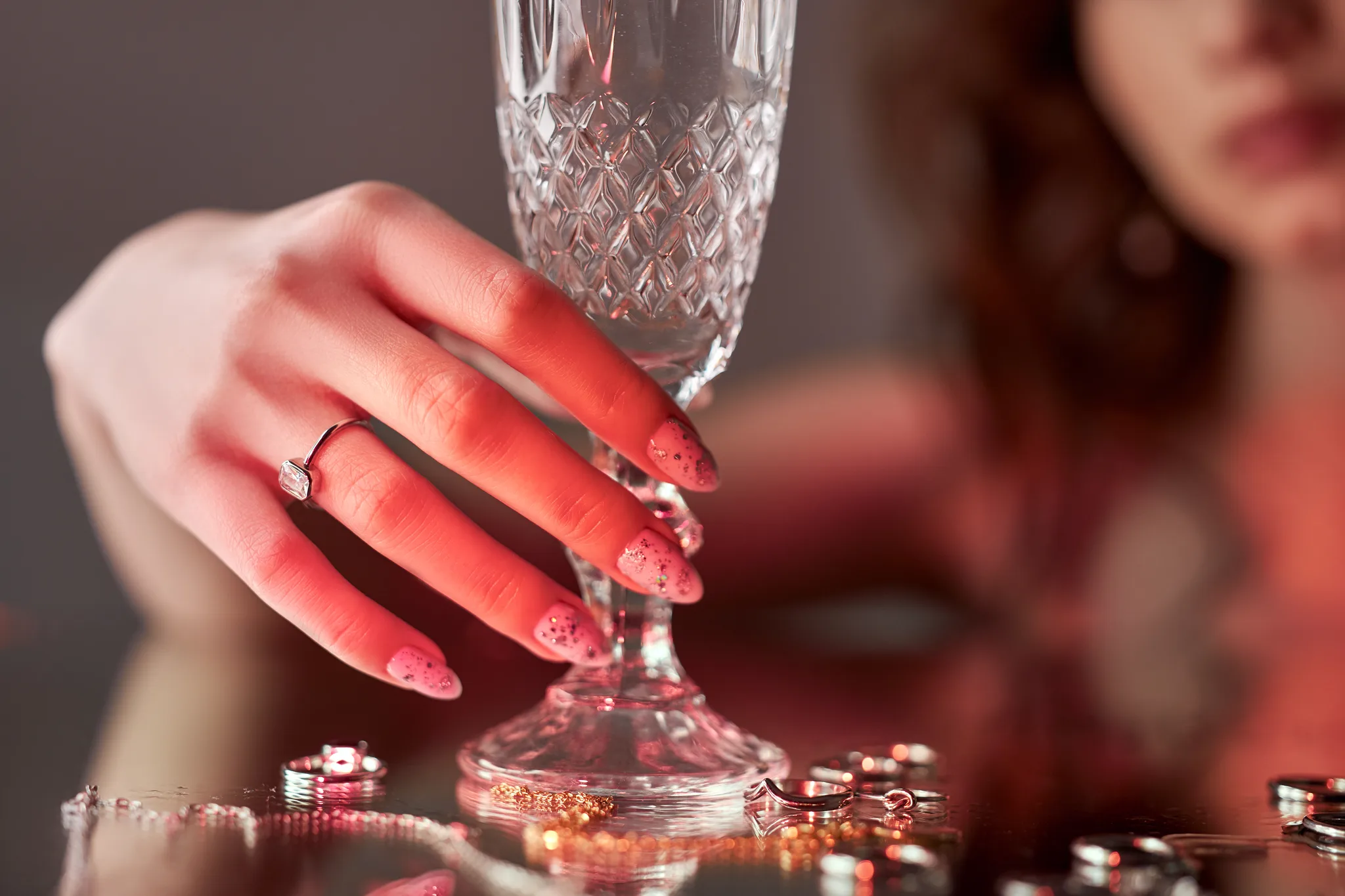 a woman holding a champagne glass, diamond nails