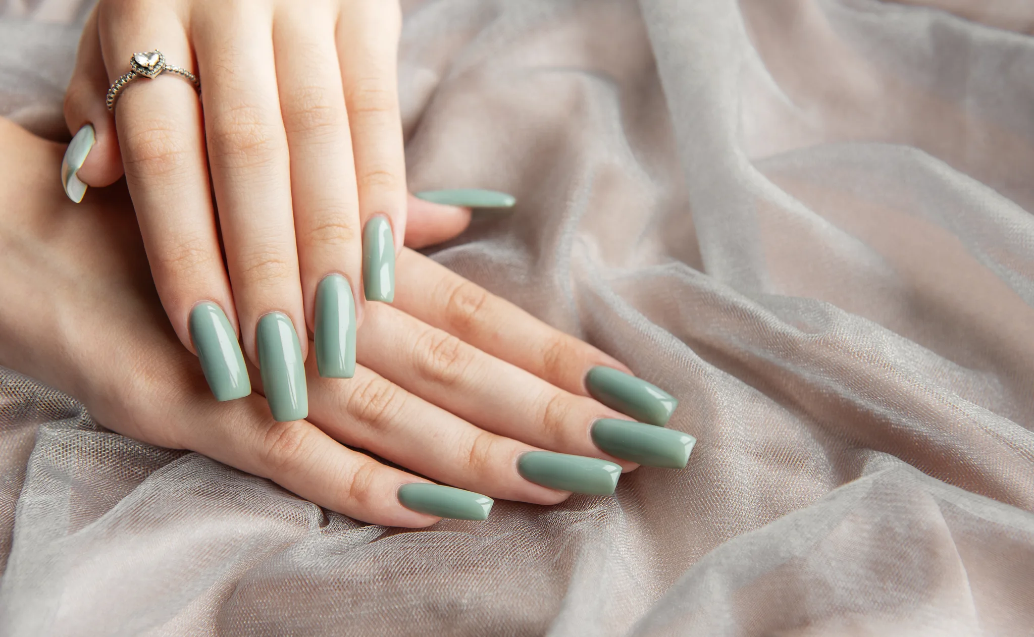 green manicure and a heart ring