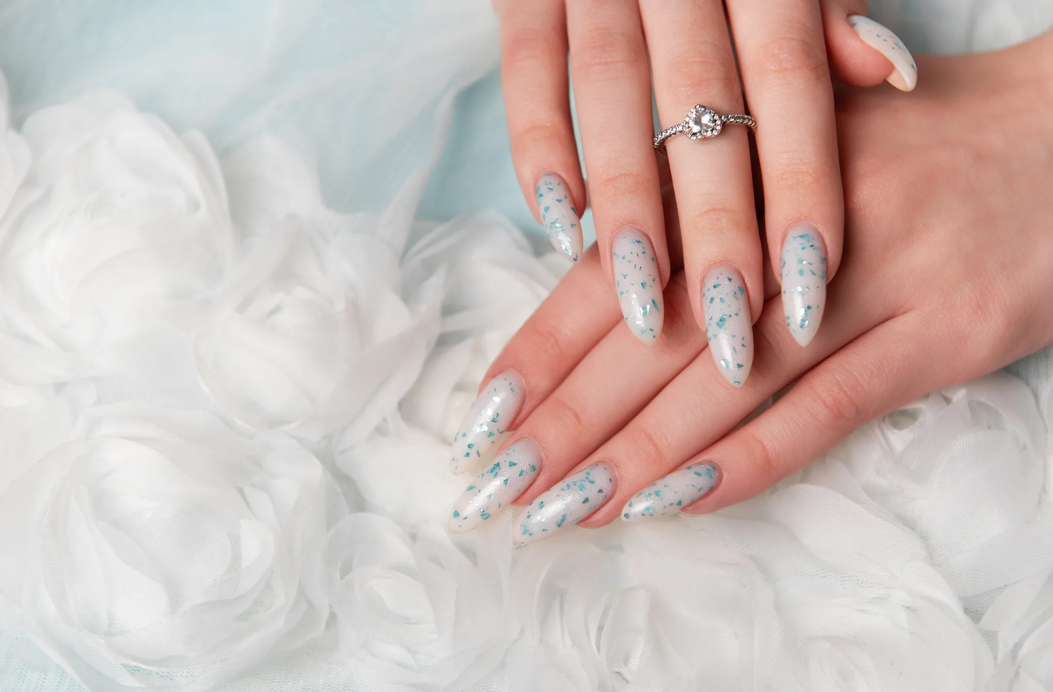 decorated fingernails and a ring on white roses